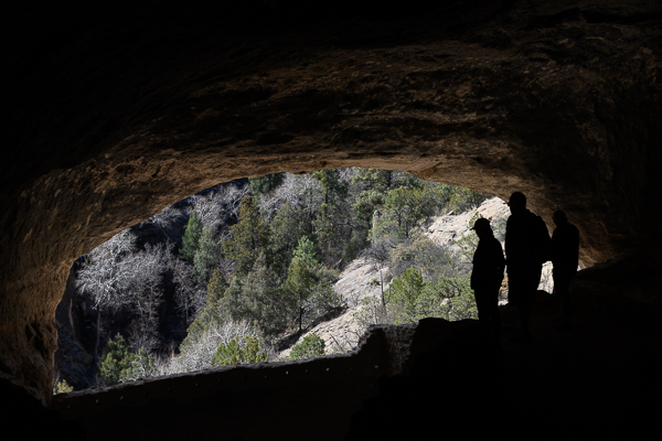Silhouettes of 3 people standing in an archway