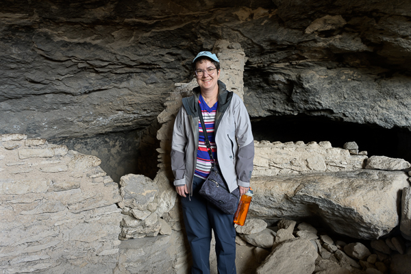 Lale in front of a cliff dwelling